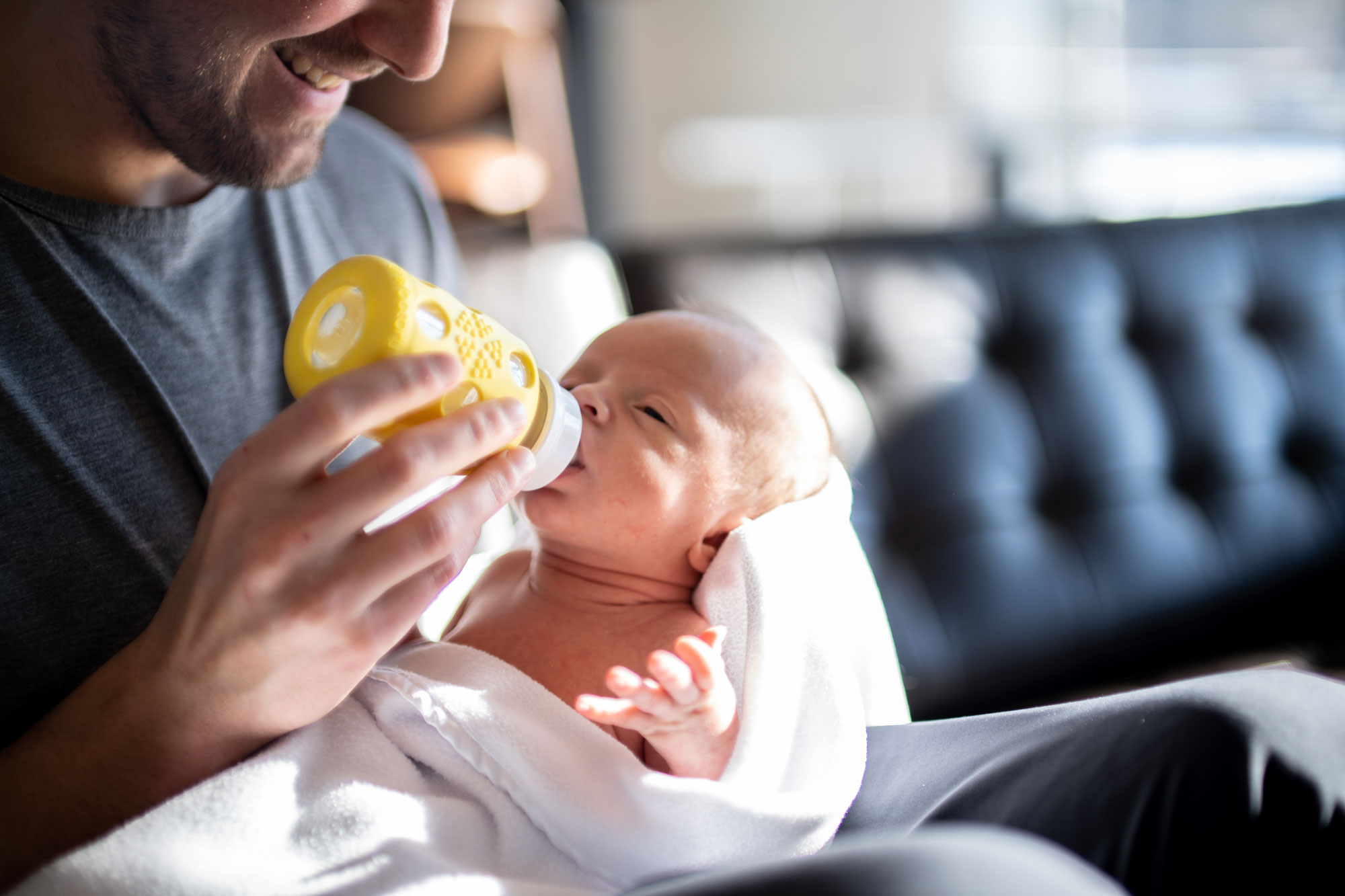 Father feeding baby with bottle