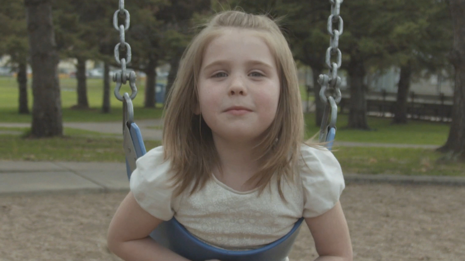 Girl smiling on the swings